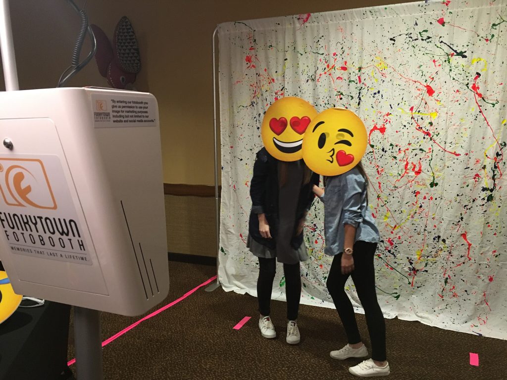 Faces in front of custom photo booth backdrop